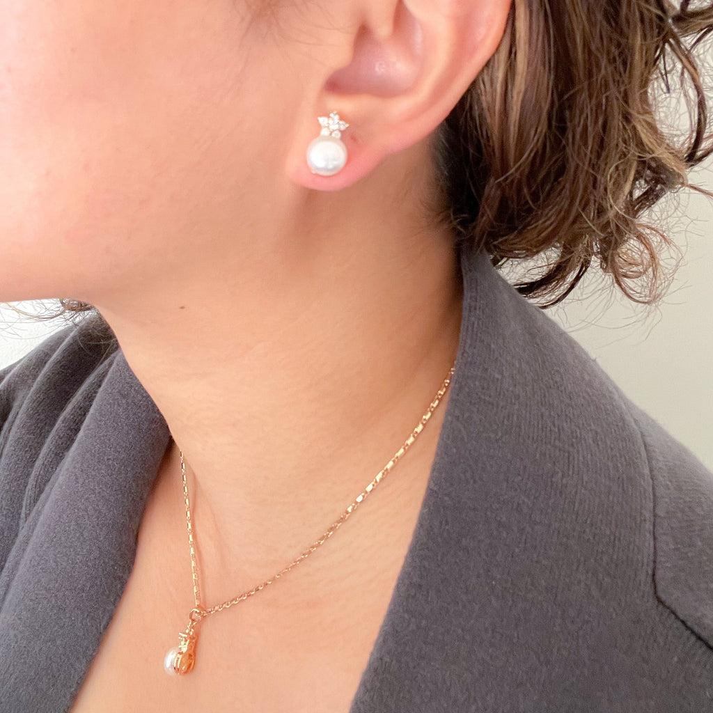 minimalist white round freshwater pearl earrings and necklace in gold plated setting with star shape cubic zirconia at the top